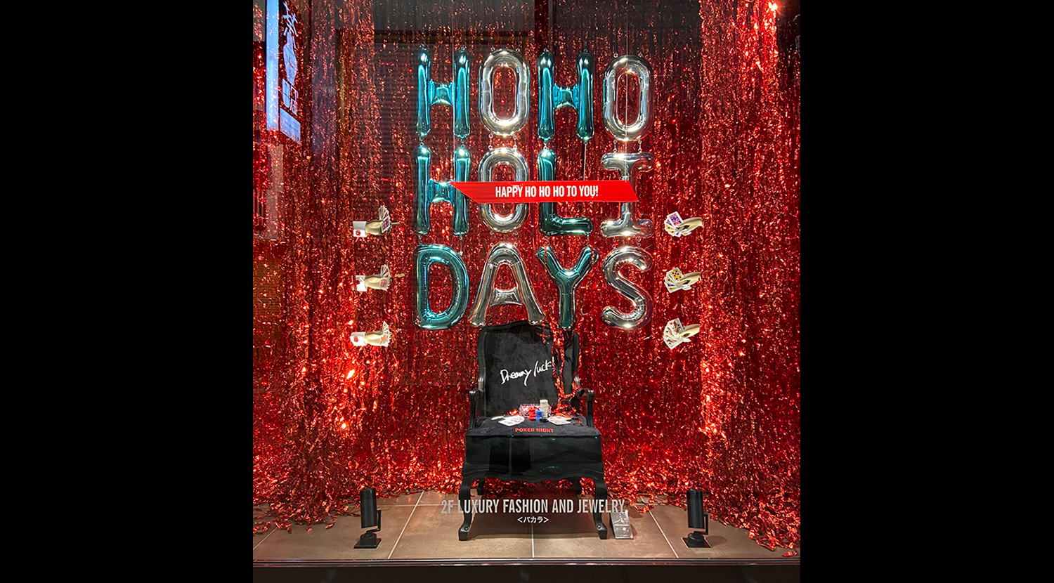 ウィンドウにもピーコックグリーンのメタリックバルーンと、パーティー感を表現する赤いクラッカーのリボンテープが華やいだ雰囲気の画像